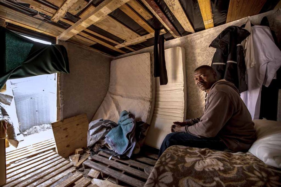 Migrant from Sudan takes cover from rain inside a makeshift hut Migrant from Sudan takes cover from rain inside a makeshift hut