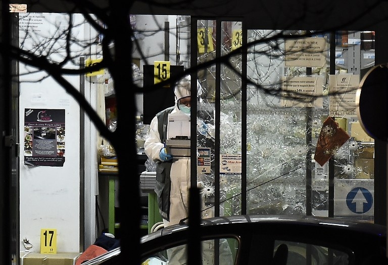 A forensic police officer by the bullet-riddled windows of the Hyper Casher store on January 9, 2015 A forensic police officer by the bullet-riddled windows of the Hyper Casher store on January 9, 2015