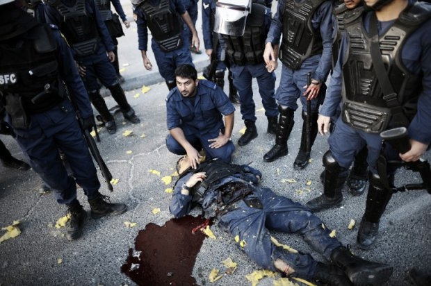 A Bahraini police man helps an injured comrade after a bomb exploded during clashes between protesters and security forces on March 3, 2014 in the village of Daih A Bahraini police man helps an injured comrade after a bomb exploded during clashes between protesters and security forces on March 3, 2014 in the village of Daih