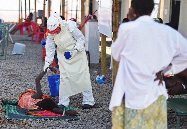 A health worker assists an Ebola patient at the Kenema treatment center A health worker assists an Ebola patient at the Kenema treatment center