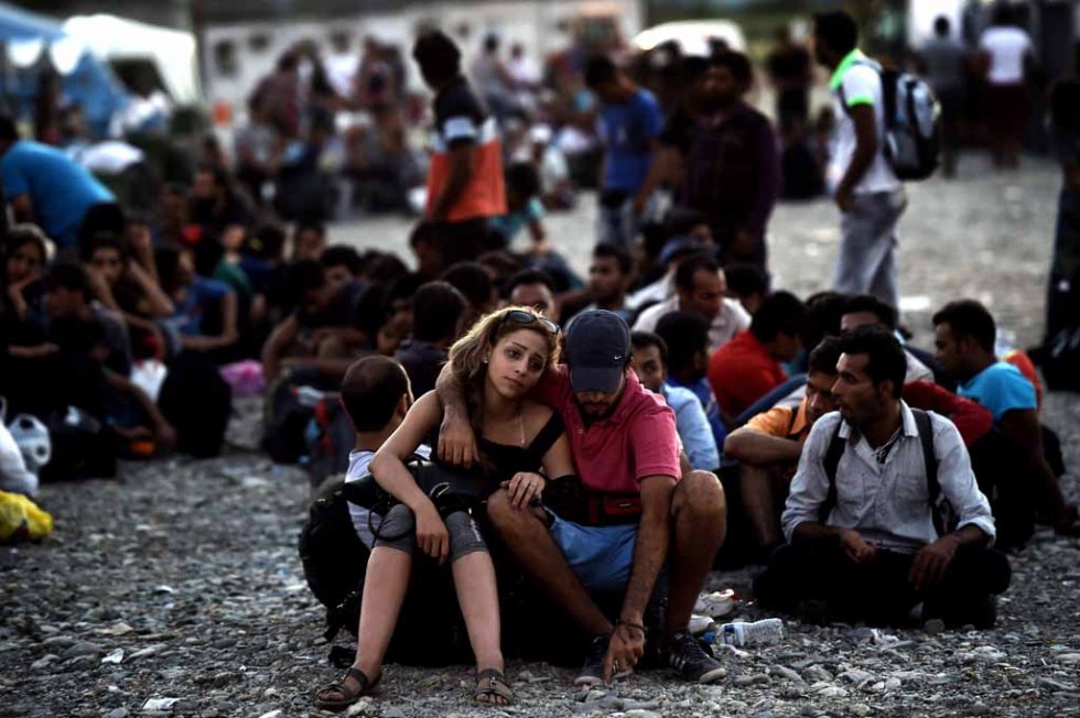 A Syrian couple waits with other migrants for a train in Macedonia in late August. A Syrian couple waits with other migrants for a train in Macedonia in late August.