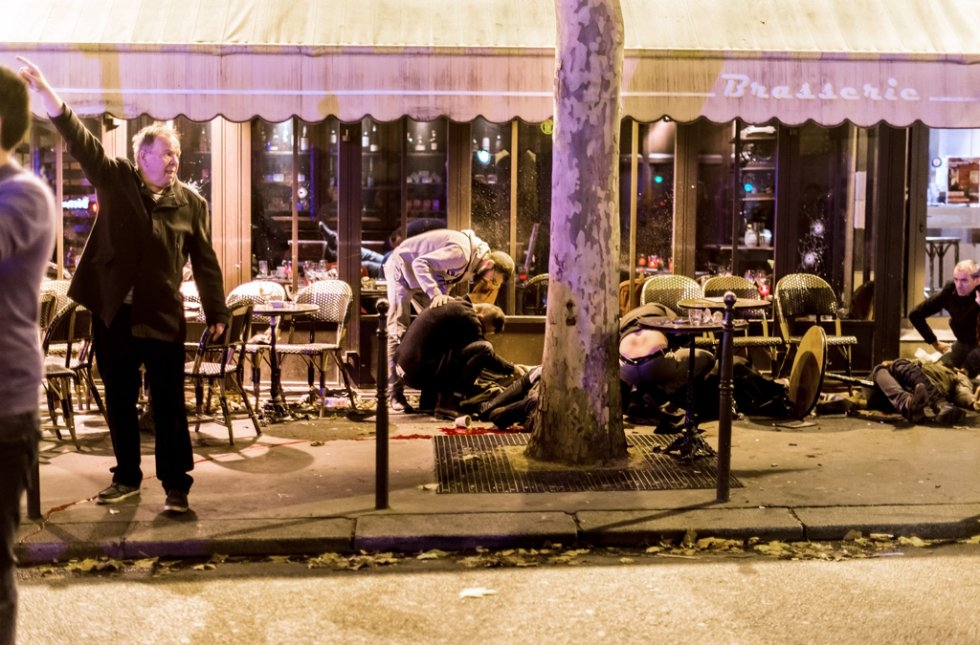 People lie on the pavement outside a cafe. People lie on the pavement outside a cafe.
