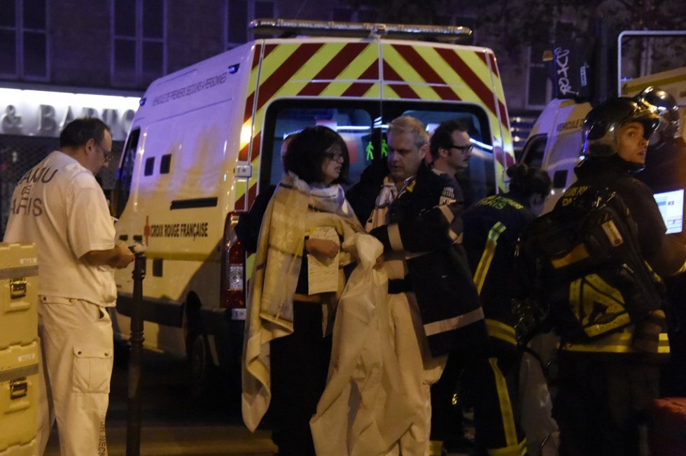 Medics help a woman outside the Bataclan concert hall. Medics help a woman outside the Bataclan concert hall.