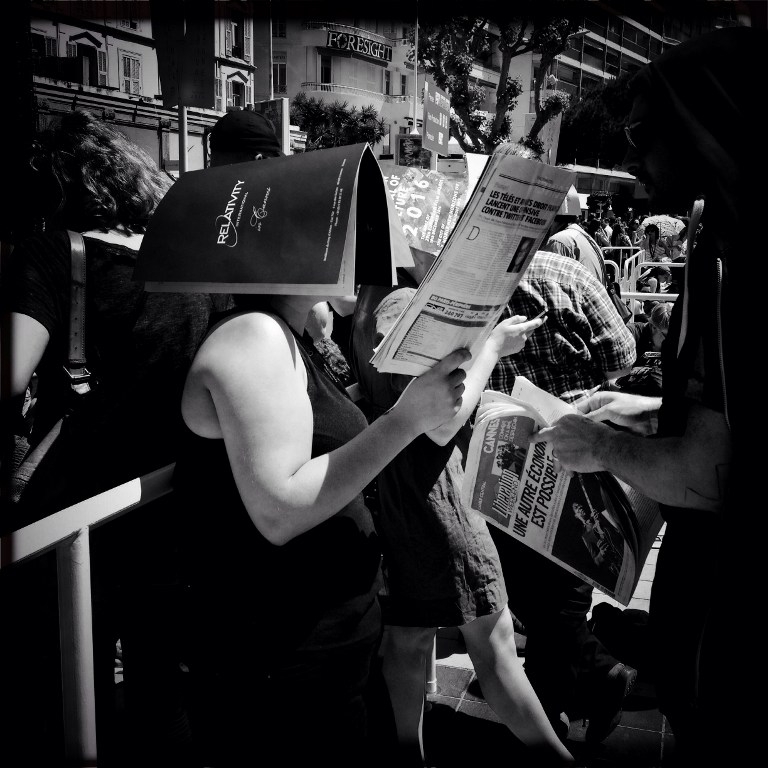 A woman shields herself with a film trade magazine during the Cannes Film Festival on May 16, 2015 A woman shields herself with a film trade magazine during the Cannes Film Festival on May 16, 2015