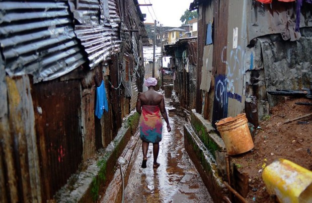 A woman walks through Kroo town slum in Freetown on August 13, 2014 A woman walks through Kroo town slum in Freetown on August 13, 2014