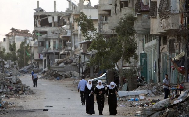 Palestinian girls walk past buildings which were destroyed by Israeli strikes on their way to school in the Shejaiya neighbourhood of Gaza City on September 14, 2014 Palestinian girls walk past buildings which were destroyed by Israeli strikes on their way to school in the Shejaiya neighbourhood of Gaza City on September 14, 2014