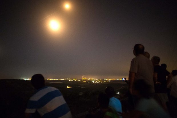 Israeli residents, mostly from the southern Israeli city of Sderot, stand on a hill overlooking the Gaza Strip, on July 12, 2014, to watch the fighting between the Israeli army and Palestinian militants Israeli residents, mostly from the southern Israeli city of Sderot, stand on a hill overlooking the Gaza Strip, on July 12, 2014, to watch the fighting between the Israeli army and Palestinian militants