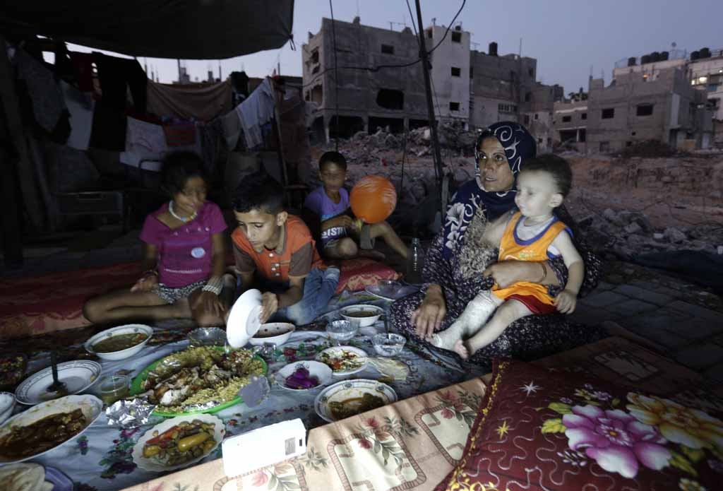 A Palestinian family gathers for the iftar meal breaking the Ramadan fast in the rubble of Beit Hanun, northern Gaza Strip on July 6, 2015 A Palestinian family gathers for the iftar meal breaking the Ramadan fast in the rubble of Beit Hanun, northern Gaza Strip on July 6, 2015