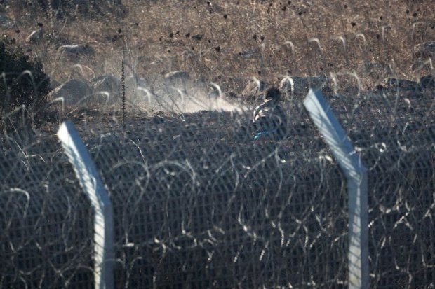A syrian rebel opens fire towards Syrian government forces near the Quneitra border crossing, on the Syrian side of the Golan, on September 1, 2014 A syrian rebel opens fire towards Syrian government forces near the Quneitra border crossing, on the Syrian side of the Golan, on September 1, 2014