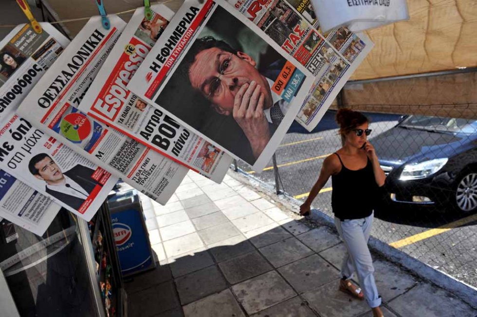 A woman passes a newspaper kiosk with headlines showing the results of Greece's referendum, in Thessaloniki, on July 6, 2015 A woman passes a newspaper kiosk with headlines showing the results of Greece's referendum, in Thessaloniki, on July 6, 2015