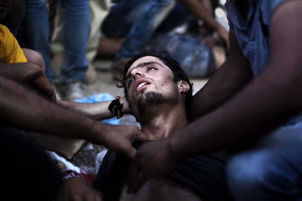 A man collapses as police try to disperse migrants in Kos. September, 2015. A man collapses as police try to disperse migrants in Kos. September, 2015.
