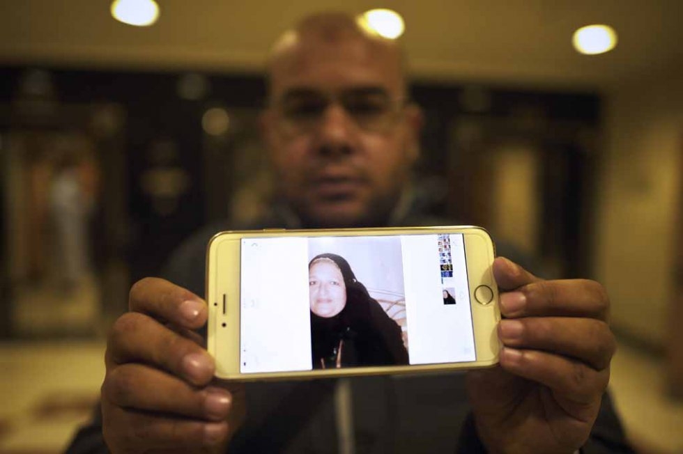 A relative of a missing victim shows her picture as he searches for her at Mina hospital after the stampede. A relative of a missing victim shows her picture as he searches for her at Mina hospital after the stampede.