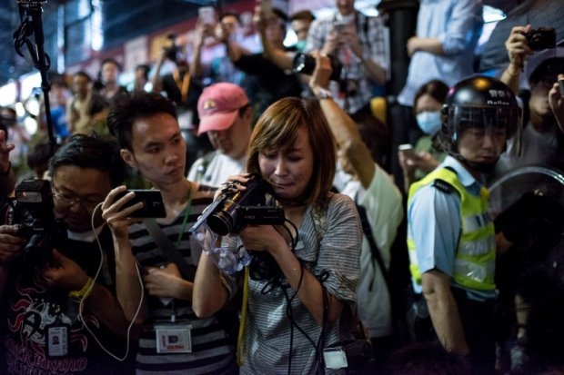 A local Hong Kong journalist (C) cries as she films a colleague who was pepper sprayed after trying to stop police from pushing her, in the Mongkok district of Hong Kong on October 17, 2014 (AFP Photo / Alex Ogle) A local Hong Kong journalist (C) cries as she films a colleague who was pepper sprayed after trying to stop police from pushing her, in the Mongkok district of Hong Kong on October 17, 2014 (AFP Photo / Alex Ogle)