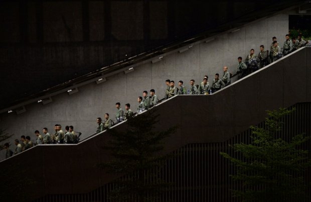 Police walk down a stairwell as pro-democracy demonstrators gather for a rally outside the Hong Kong government headquarters on September 29, 2014 Police walk down a stairwell as pro-democracy demonstrators gather for a rally outside the Hong Kong government headquarters on September 29, 2014