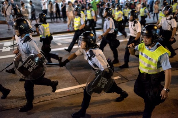 Police officers run along a road during clashes with pro-democracy protesters in the Mongkok district of Hong Kong on October 18, 2014 (AFP Photo / Alex Ogle) Police officers run along a road during clashes with pro-democracy protesters in the Mongkok district of Hong Kong on October 18, 2014 (AFP Photo / Alex Ogle)