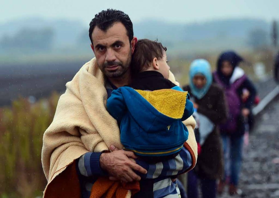 A migrant family arrives in Hungary near Röszke on September 10, 2015 A migrant family arrives in Hungary near Röszke on September 10, 2015