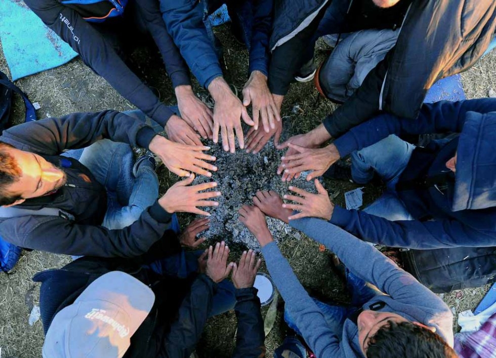 Refugees warm up at the "migrant collection point" near Röszke on September 8, 2015 Refugees warm up at the "migrant collection point" near Röszke on September 8, 2015