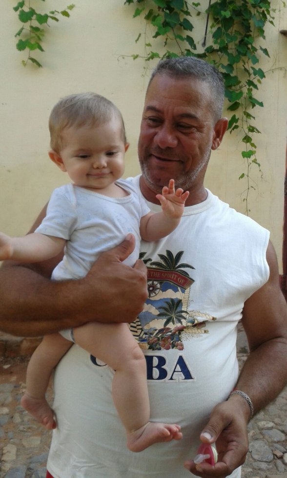 B&B owner in Trinidad holds author's baby, September, 2015. (Photo courtesy of Celia Schlanser) B&B owner in Trinidad holds author's baby, September, 2015. (Photo courtesy of Celia Schlanser)
