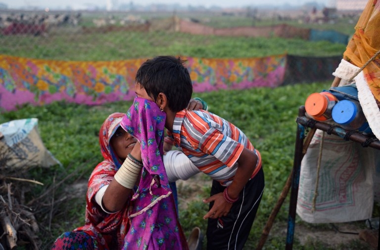 Nomadic shepherd Dukki washes her daughter Kamla Kumari's face at their camp in Sikri in Faridabad district on March 25, 2015 Nomadic shepherd Dukki washes her daughter Kamla Kumari's face at their camp in Sikri in Faridabad district on March 25, 2015