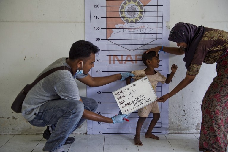 A Rohingya boy from Myanmar is photographed during police identification procedures at a newly set up confinement area in Bayeun, in Indonesia's Aceh province A Rohingya boy from Myanmar is photographed during police identification procedures at a newly set up confinement area in Bayeun, in Indonesia's Aceh province