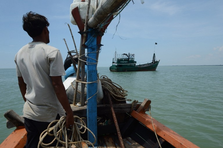 A local fisherman who helped rescue migrant Rohingya from Myanmar and Bangladesh, looks at their abandoned ship off the coast in Indonesia's Aceh province on May 20, 2015 A local fisherman who helped rescue migrant Rohingya from Myanmar and Bangladesh, looks at their abandoned ship off the coast in Indonesia's Aceh province on May 20, 2015