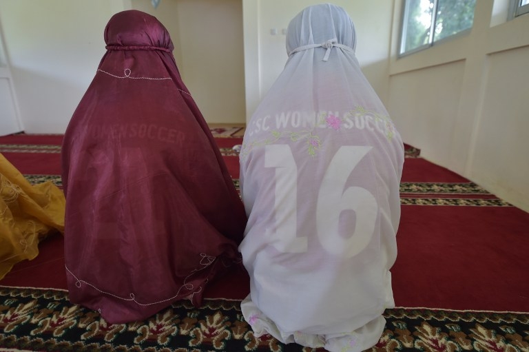 Women footballers pray before a training session in Jakarta on March 26, 2015 Women footballers pray before a training session in Jakarta on March 26, 2015