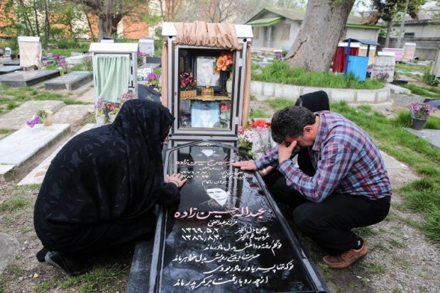Samereh Alinejad and Abdolghani Hosseinzadeh mourn at the grave of their son Samereh Alinejad and Abdolghani Hosseinzadeh mourn at the grave of their son