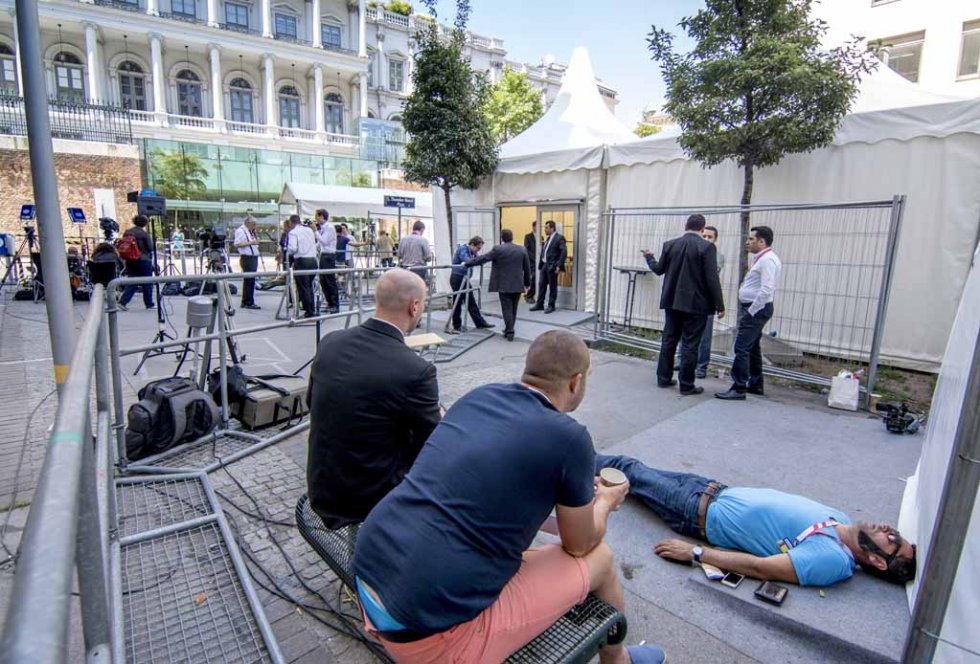 A journalist rests outside the Palais Coburg Hotel in Vienna on July 3, 2015 A journalist rests outside the Palais Coburg Hotel in Vienna on July 3, 2015