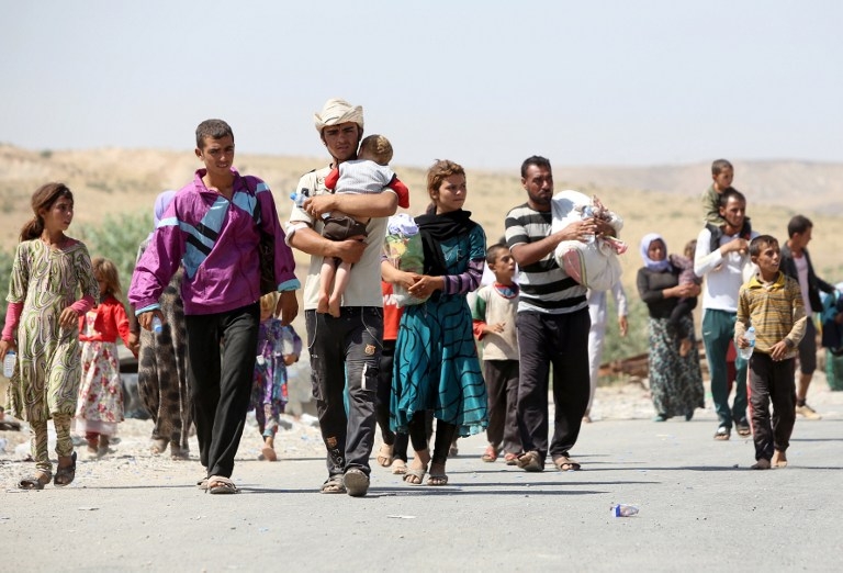 Yazidi Iraqis fleeing the Islamic State group cross into Syria at Fishkhabur on August 11, 2014 Yazidi Iraqis fleeing the Islamic State group cross into Syria at Fishkhabur on August 11, 2014