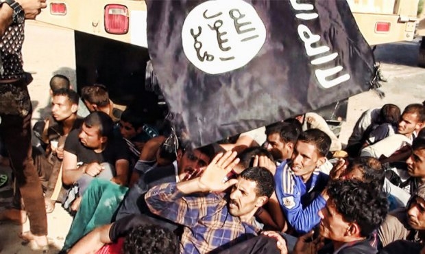 IS militants wave a flag above the heads of prisoners who are about to be executed. IS militants wave a flag above the heads of prisoners who are about to be executed.