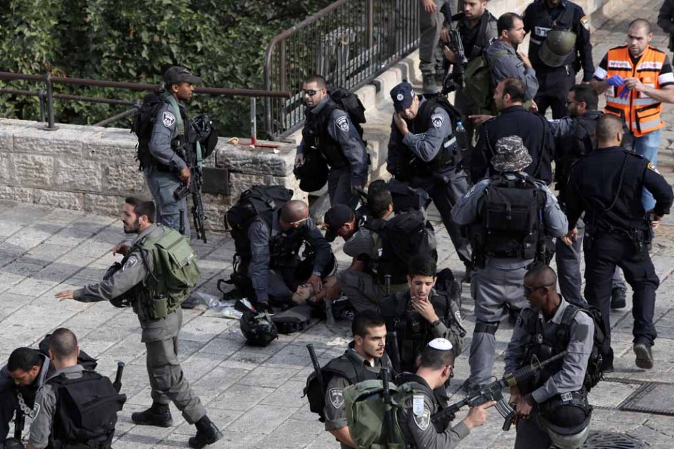 Israeli border guards give first aid to a police officer who was stabbed by a Palestinian in the Old City of Jerusalem. Israeli border guards give first aid to a police officer who was stabbed by a Palestinian in the Old City of Jerusalem.