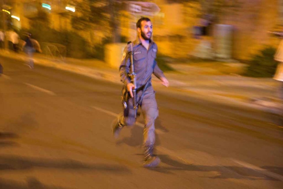 An Israeli policeman rushes to the site of a stabbing near Jerusalem's central bus terminal. An Israeli policeman rushes to the site of a stabbing near Jerusalem's central bus terminal.