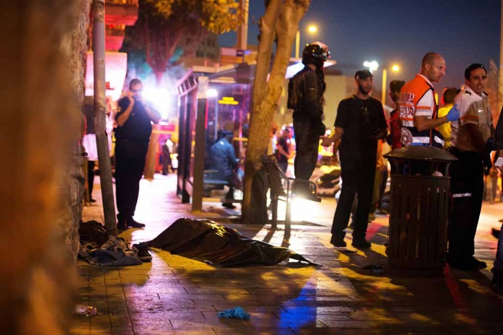 The body of an attacker who stabbed a woman near Jerusalem's central bus terminal lies on the ground after he was shot dead. The body of an attacker who stabbed a woman near Jerusalem's central bus terminal lies on the ground after he was shot dead.