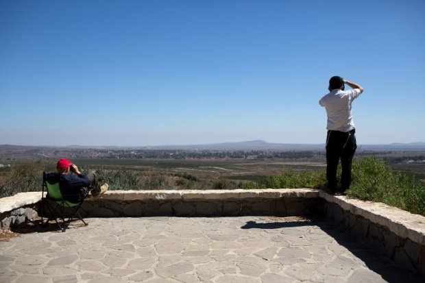 Israeli civilians stand near Mount Bental, in the Israeli-annexed Golan Heights, as they watch through binoculars the fighting between Syrian government troops and Islamist rebel fighters on September 2, 2014 Israeli civilians stand near Mount Bental, in the Israeli-annexed Golan Heights, as they watch through binoculars the fighting between Syrian government troops and Islamist rebel fighters on September 2, 2014