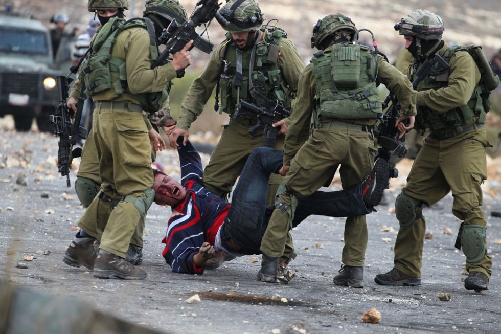 Israely soldiers detain a wounded Palestinian stone thrower during clashes in Beit El, on the outskirts of the West Bank city of Ramallah, on October 7, 2015 (AFP / Abbas Momani) Israely soldiers detain a wounded Palestinian stone thrower during clashes in Beit El, on the outskirts of the West Bank city of Ramallah, on October 7, 2015 (AFP / Abbas Momani)