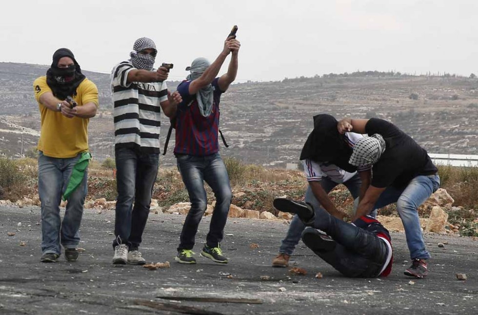Infiltrated members of the Israeli security forces detain a Palestinian stone thrower and aim their weapons at fellow protesters during clashes in Beit El, on the outskirts of the West Bank city of Ramallah, on October 7, 2015 (AFP / Abbas Momani) Infiltrated members of the Israeli security forces detain a Palestinian stone thrower and aim their weapons at fellow protesters during clashes in Beit El, on the outskirts of the West Bank city of Ramallah, on October 7, 2015 (AFP / Abbas Momani)