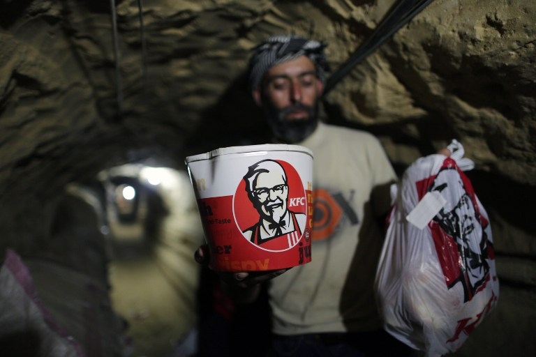 A smuggler carries Kentucky Fried Chicken food through a tunnel linking the Gaza Strip to Egypt A smuggler carries Kentucky Fried Chicken food through a tunnel linking the Gaza Strip to Egypt