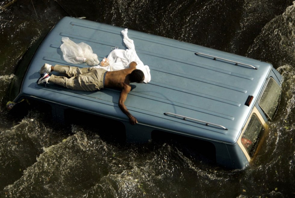 A man clings to the top of a vehicle prior to being rescued by the US Coast Guard from the flooded streets in the aftermath of Hurricane Katrina in New Orleans, Louisiana, 04 September, 2005. (AFP Photo / pool / Robert Galbraith) A man clings to the top of a vehicle prior to being rescued by the US Coast Guard from the flooded streets in the aftermath of Hurricane Katrina in New Orleans, Louisiana, 04 September, 2005. (AFP Photo / pool / Robert Galbraith)