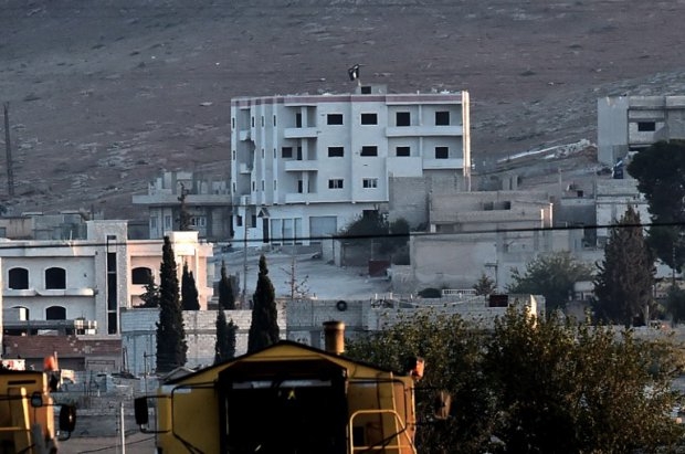 Another Islamic State flag flutters on the roof of a building inside Kobane Another Islamic State flag flutters on the roof of a building inside Kobane