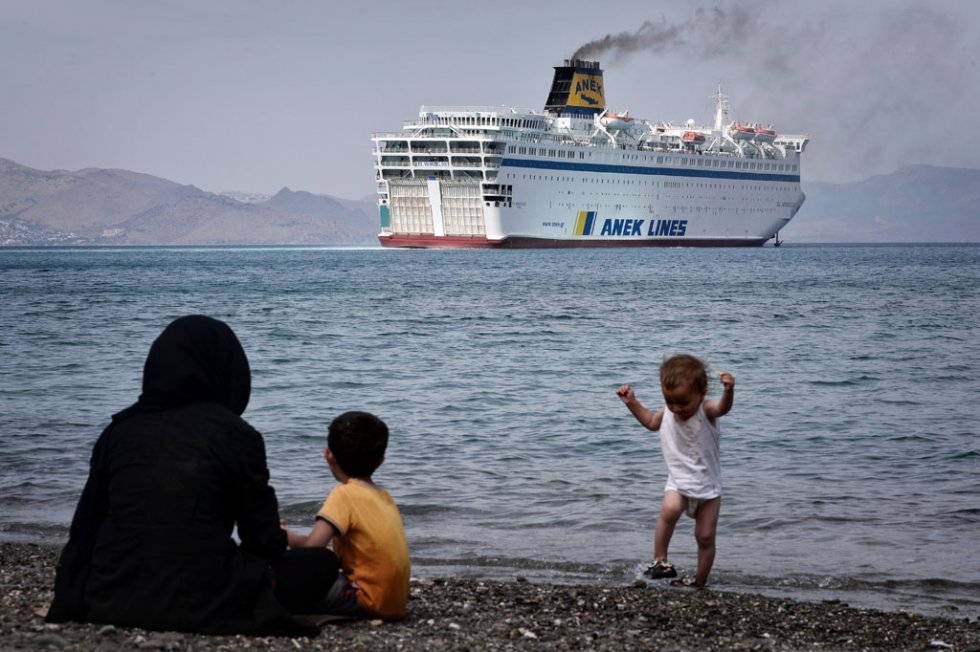 Syrians watch a ferry arriving at the port of Kos on August 14, 2015 Syrians watch a ferry arriving at the port of Kos on August 14, 2015