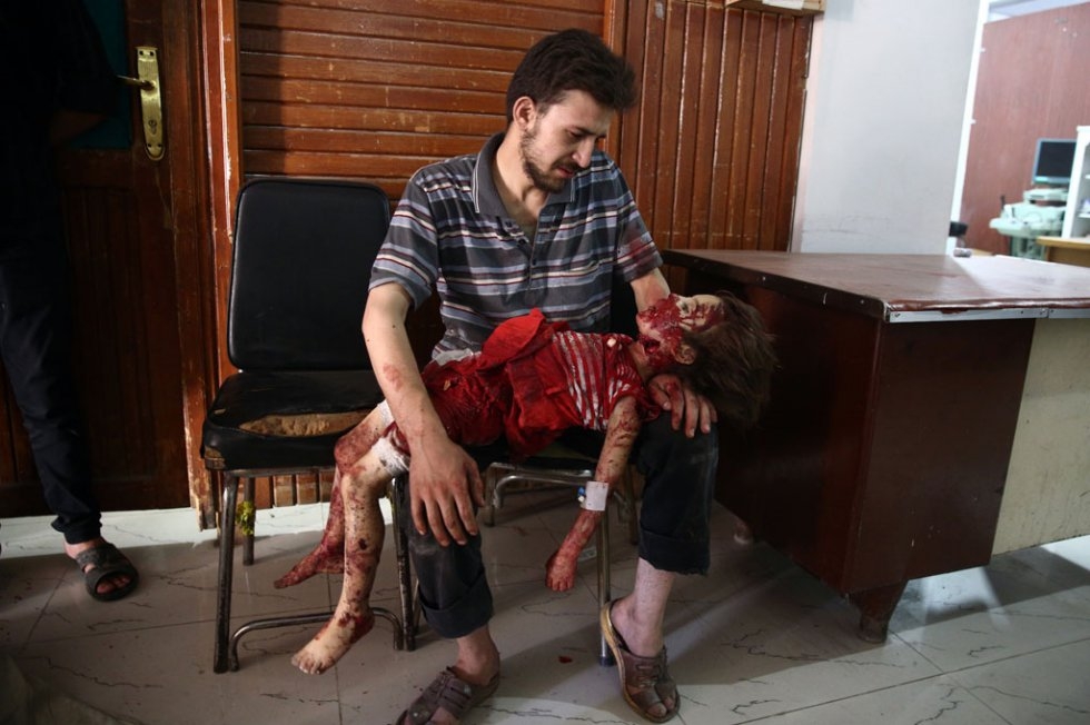 A man looks at the body of his daughter, who was killed during air raids by the Syrian government forces, on August 24, 2015 at a makeshift hospital in the rebel-held area of Douma, east of Damascus A man looks at the body of his daughter, who was killed during air raids by the Syrian government forces, on August 24, 2015 at a makeshift hospital in the rebel-held area of Douma, east of Damascus