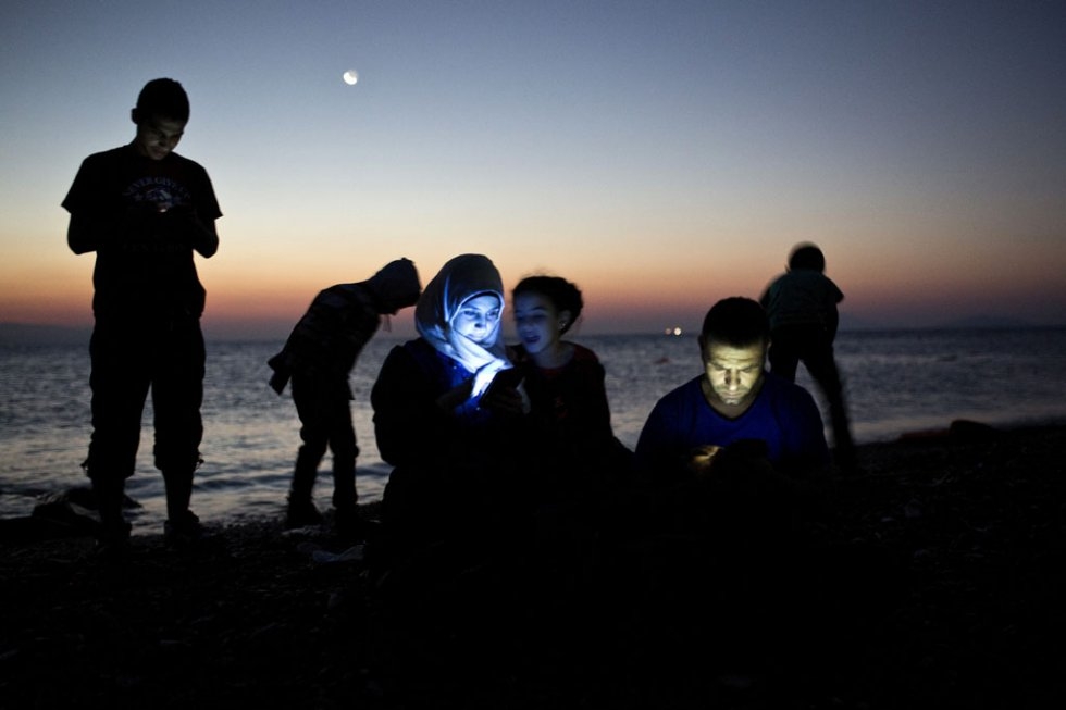 Migrants check their mobile phones on a beach after reaching the Greek island of Kos on August 12, 2015 (AFP Photo / Angelos Tzortzinis) Migrants check their mobile phones on a beach after reaching the Greek island of Kos on August 12, 2015 (AFP Photo / Angelos Tzortzinis)