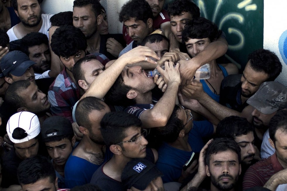 Migrants wait to complete a registration procedure by the police at a stadium on Kos on August 12, 2015 Migrants wait to complete a registration procedure by the police at a stadium on Kos on August 12, 2015