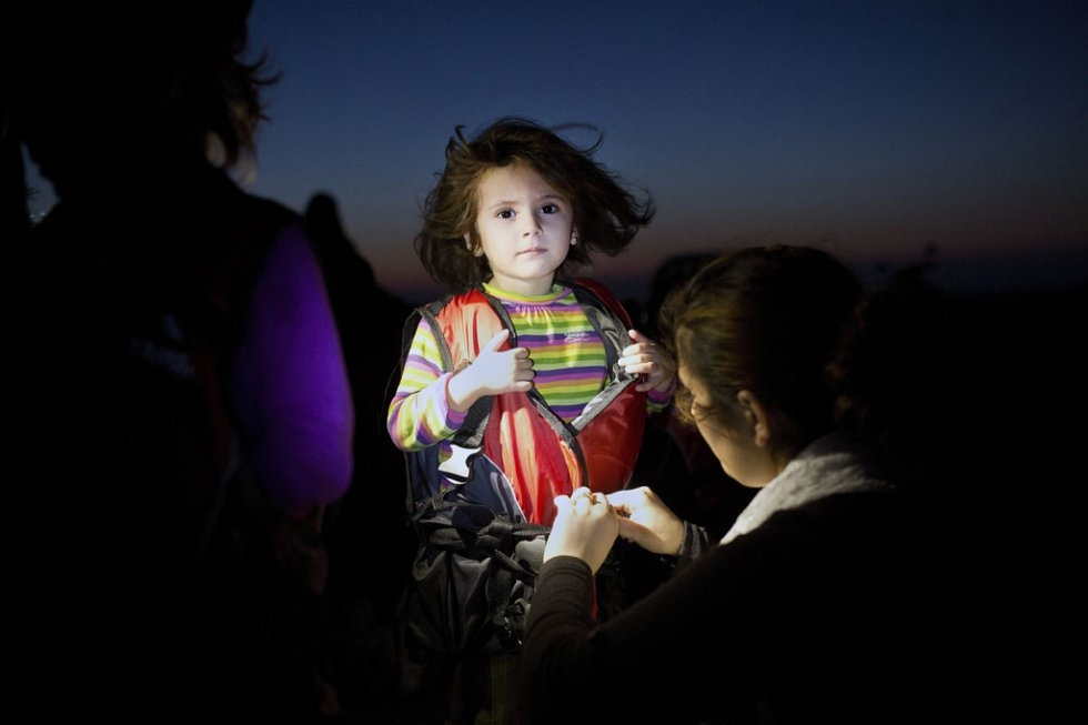 "A migrant child gets assistance to remove her life jacket after arriving in Kos on August 13, 2015 "A migrant child gets assistance to remove her life jacket after arriving in Kos on August 13, 2015