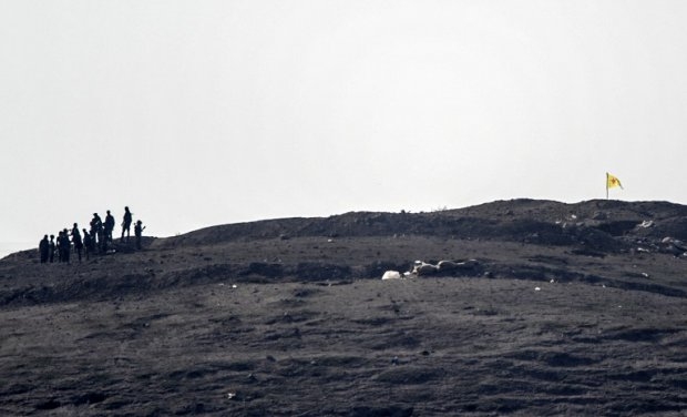 Kurdish fighters stand by a flag of the People's Protection Units (YPG) on Tilsehir hill near the Turkish border after an air strike against the Islamic State group (IS) on October 24, 2014 (AFP Photo / Bulent Kilic) Kurdish fighters stand by a flag of the People's Protection Units (YPG) on Tilsehir hill near the Turkish border after an air strike against the Islamic State group (IS) on October 24, 2014 (AFP Photo / Bulent Kilic)