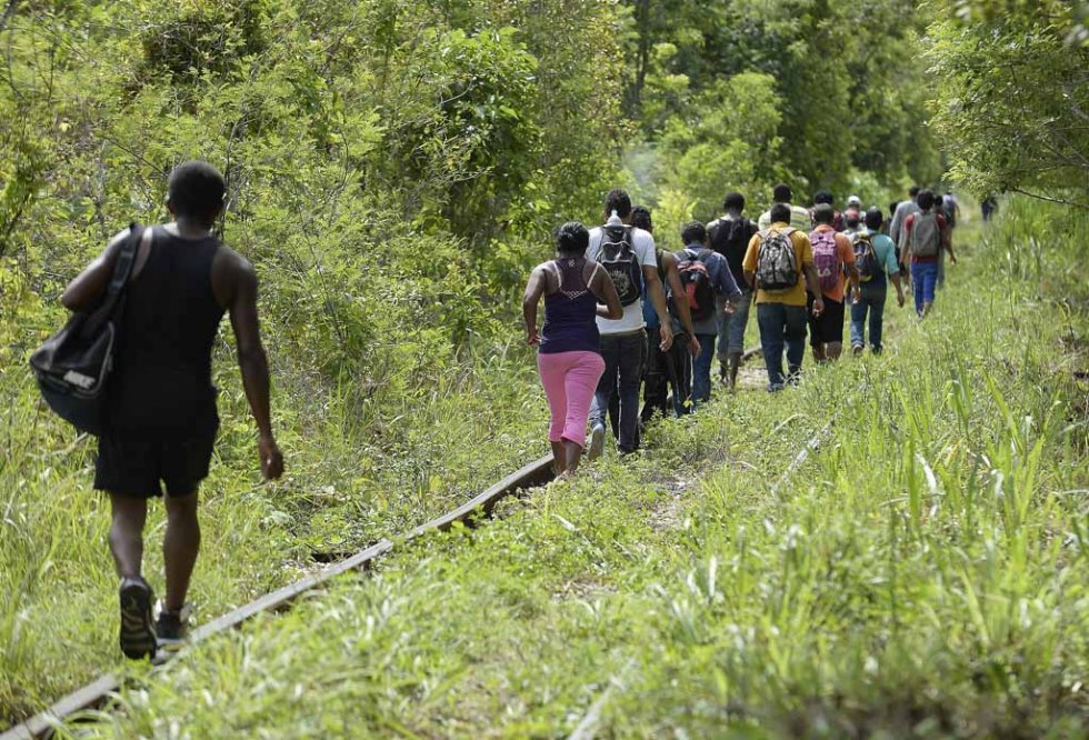 Migrants walk along the train tracks in Palenque, Chiapas State on June 19, 2015 Migrants walk along the train tracks in Palenque, Chiapas State on June 19, 2015