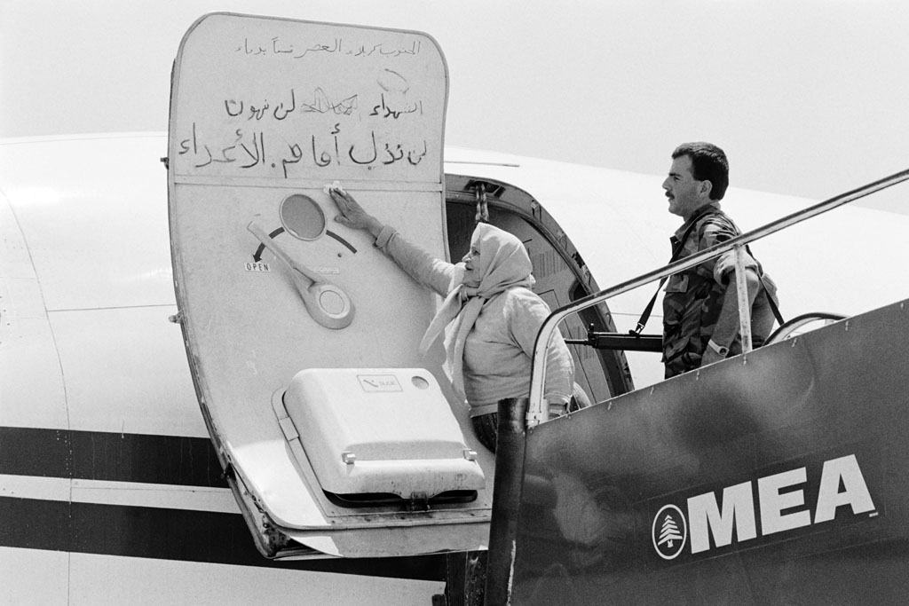 A Lebanese woman cleans off slogans written by hijackers on the door of the hijacked TWA plane, on July 6, 1985 at Beirut airport A Lebanese woman cleans off slogans written by hijackers on the door of the hijacked TWA plane, on July 6, 1985 at Beirut airport
