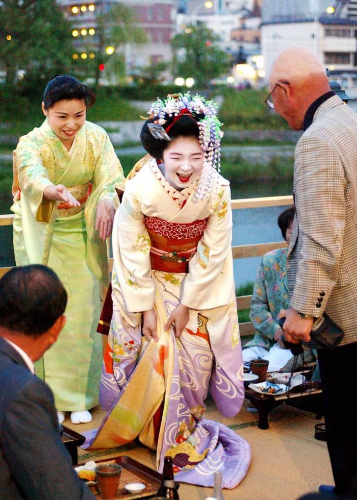 Geisha apprentices talk with guests at a traditional Japanese restaurant in Kyoto. May, 2004. Geisha apprentices talk with guests at a traditional Japanese restaurant in Kyoto. May, 2004.