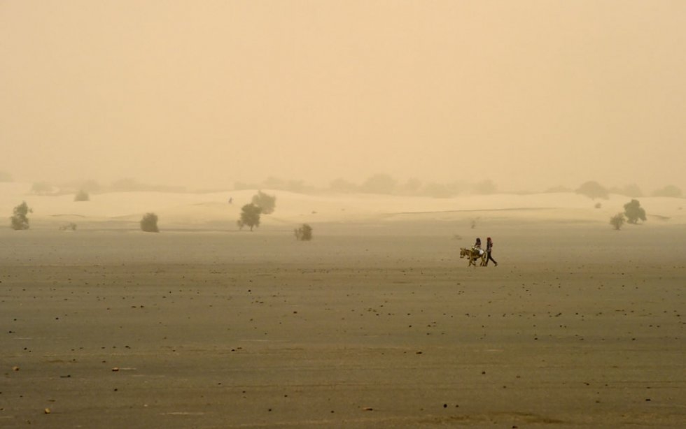 People walk across the dry lake of Faguibine near Bintagoungou in the region of Timbuktu, northern Mali, on June 4, 2015 People walk across the dry lake of Faguibine near Bintagoungou in the region of Timbuktu, northern Mali, on June 4, 2015
