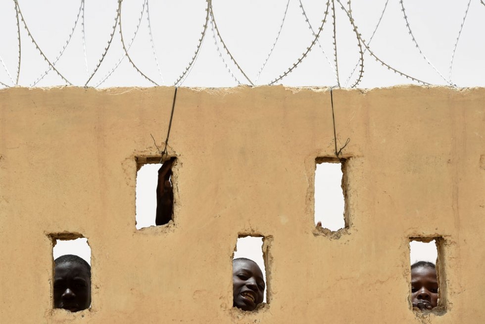 Children look through holes in a wall at the MINUSMA camp in Goundam, in Mali's Timbuktu region on June 3, 2015 Children look through holes in a wall at the MINUSMA camp in Goundam, in Mali's Timbuktu region on June 3, 2015
